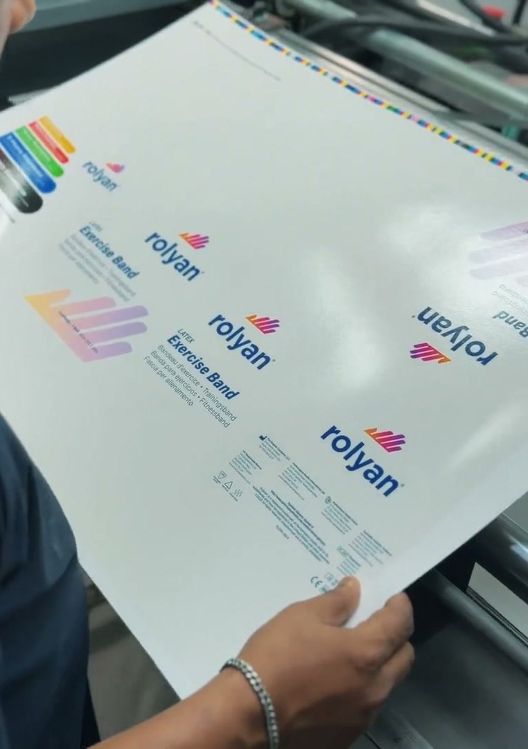 Operator checking a freshly printed full-colour sheet at the press